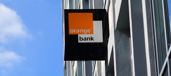 Letrero en exterior de edificio con logo de Orange Bank.
