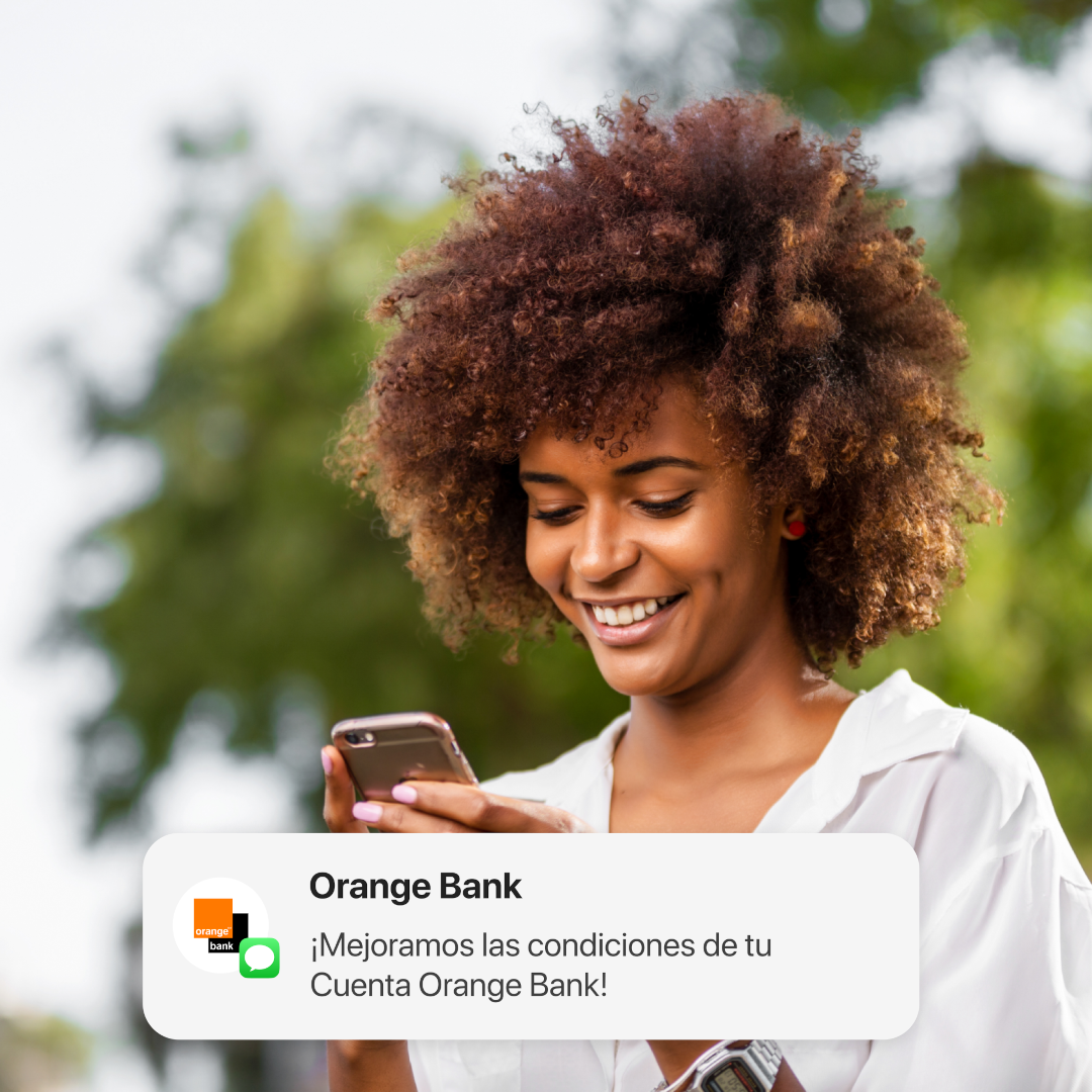 Mujer sonriente con móvil y notificación de Orange Bank.